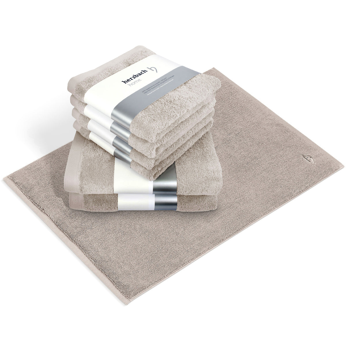 Pura Bundle Sandgrau – 6 gefaltete Handtücher mit herzbach home Banderole und Badvorleger im Set auf weißem Hintergrund
