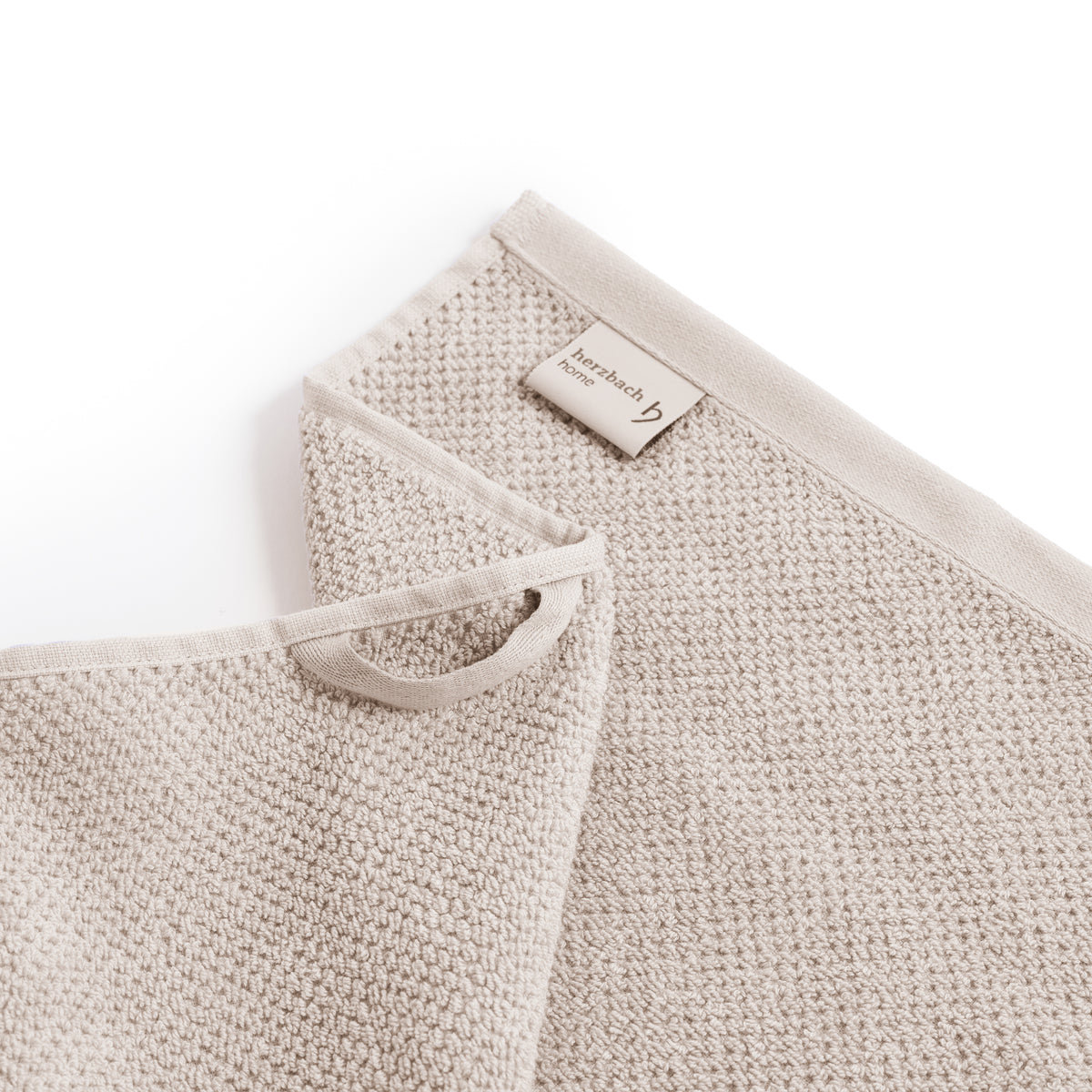 Detailansicht Aufhänger und Label des SPA Handtuchs in Sandgrau