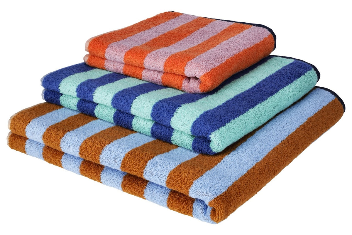Good Vibes Badetücher in drei Farbvarianten gestapelt – Türkis/Blau, Caramel/Hellblau und Mandarin/Rosa im Vergleich