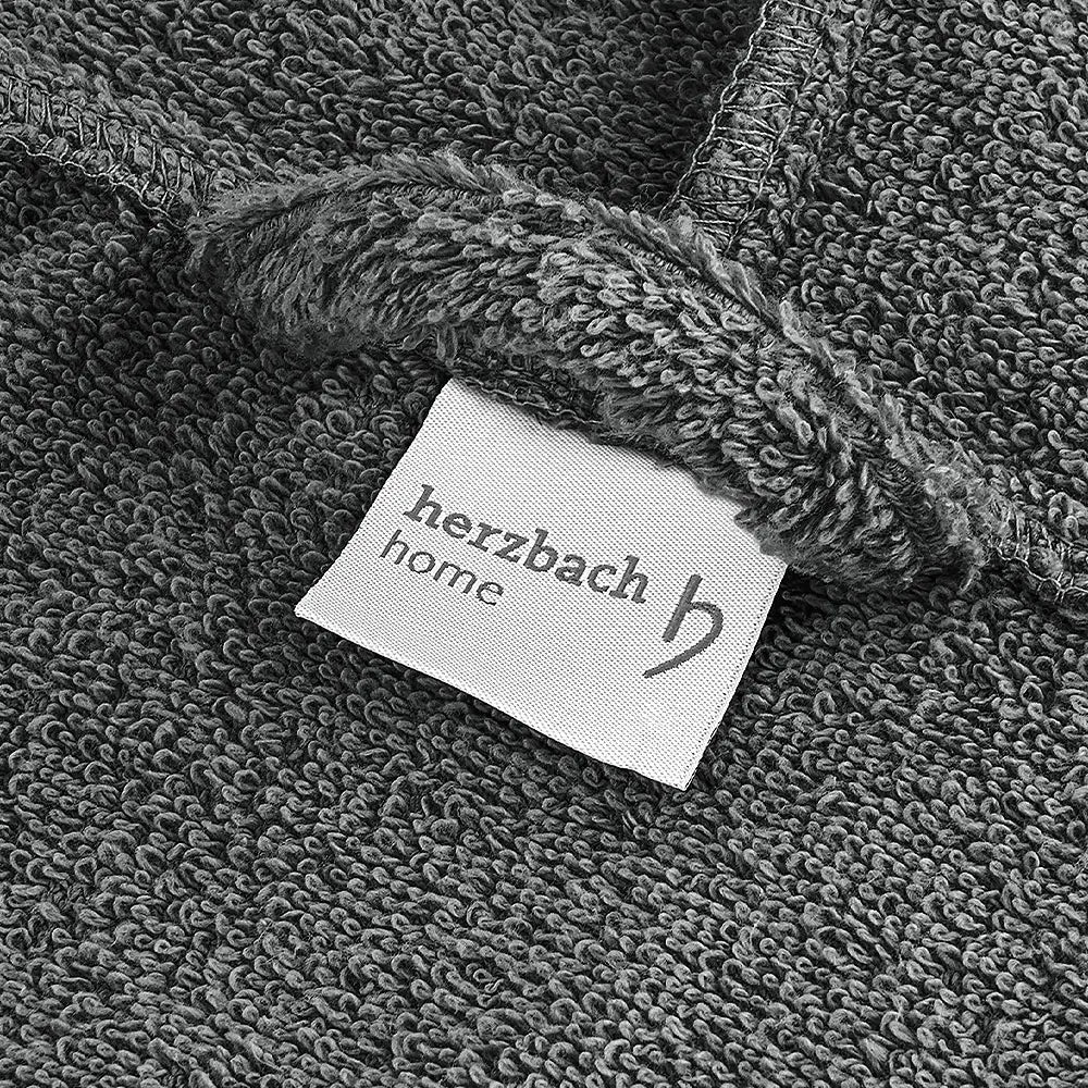 Nahaufnahme des anthrazitfarbenen Bademantelstoffs mit herzbach home Etikett