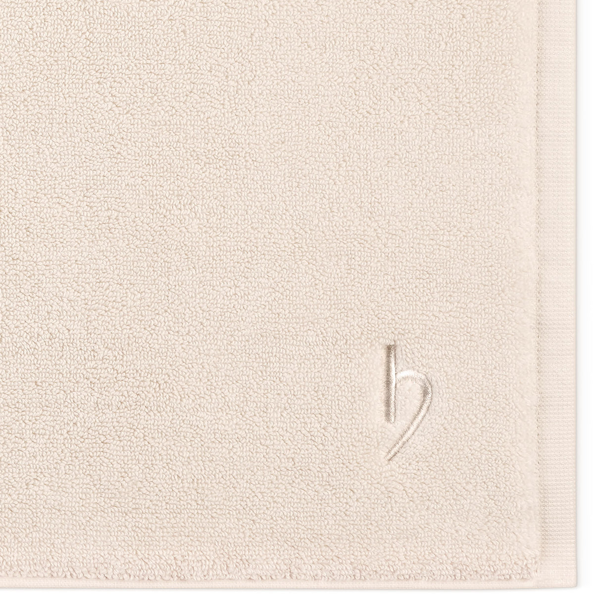 Pura Badvorleger Creme – Nahaufnahme der Ecke mit dichter Frottier-Struktur und Ton-in-Ton-Logostickerei auf cremefarbenem Untergrund