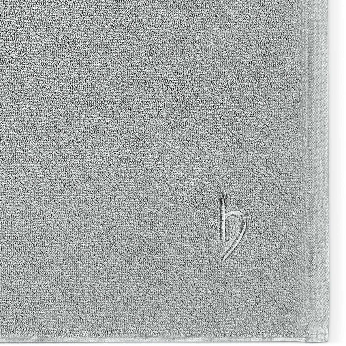 Pura Badvorleger Silbergrau – Nahaufnahme der Ecke mit dichter Frottier-Struktur und Ton-in-Ton-Logostickerei auf silbergrauem Untergrund