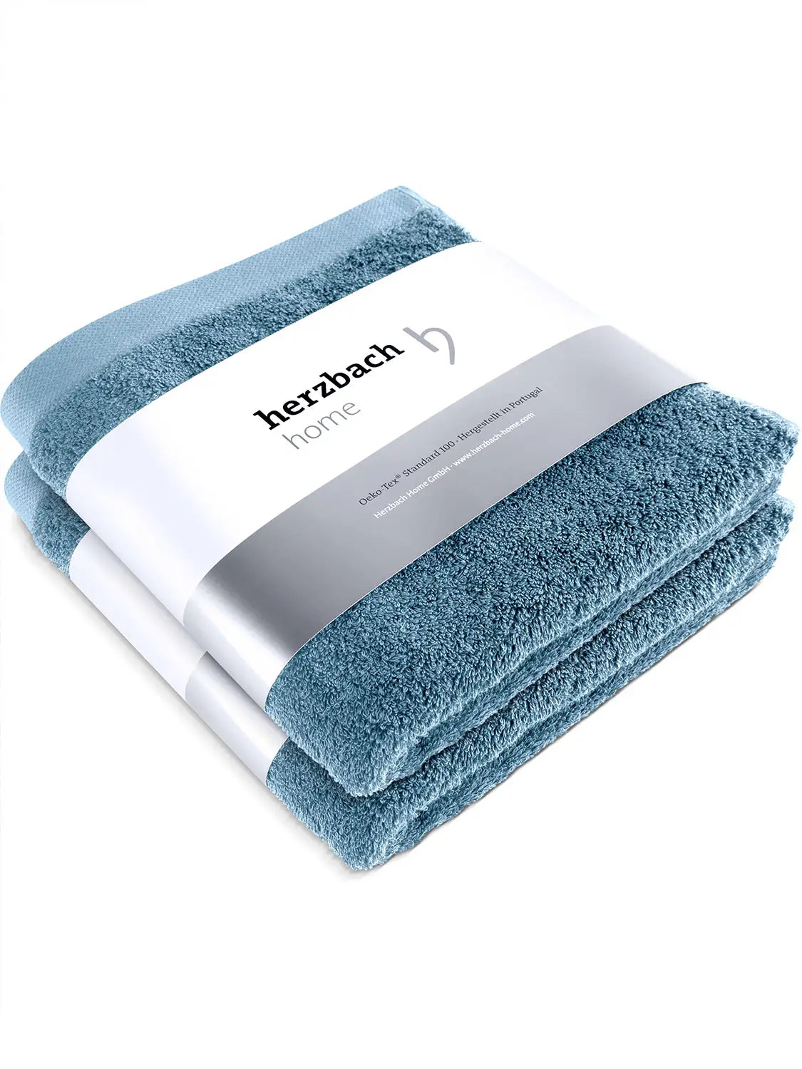 Zwei gefaltete blaue Pura Handtücher mit herzbach home Papierbanderole