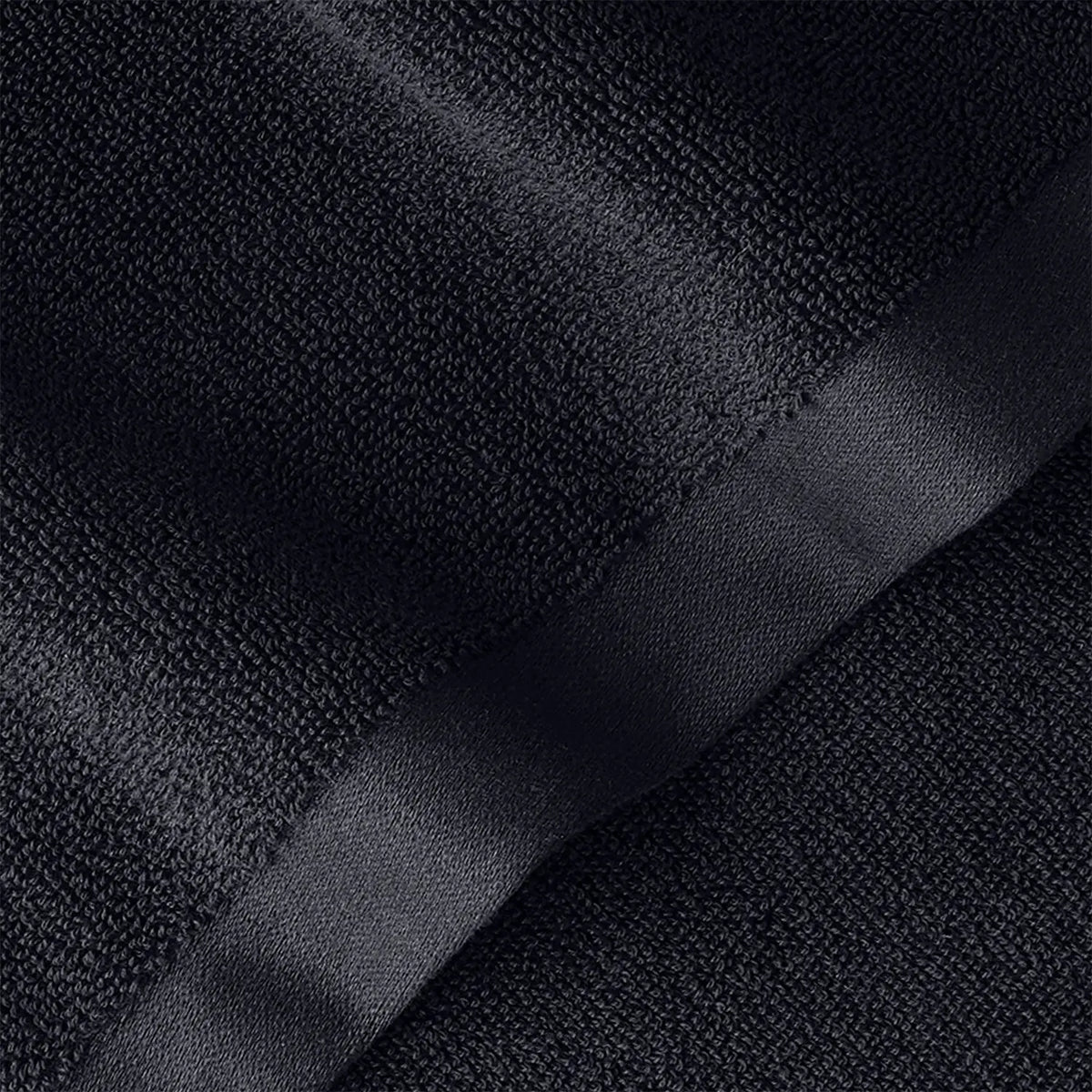 Duschtuch Tiefschwarz – Detailaufnahme der dichten Frottier-Oberfläche und des satinierten Saums in tiefem Schwarz