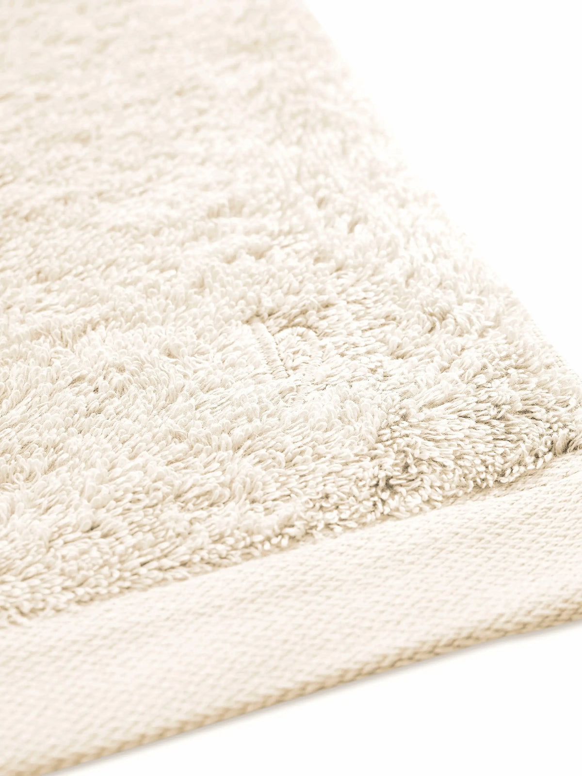 Pura Saunatuch Creme – Eckendetail mit gleichmäßiger Frottier-Oberfläche und feinem Saum in Schrägansicht