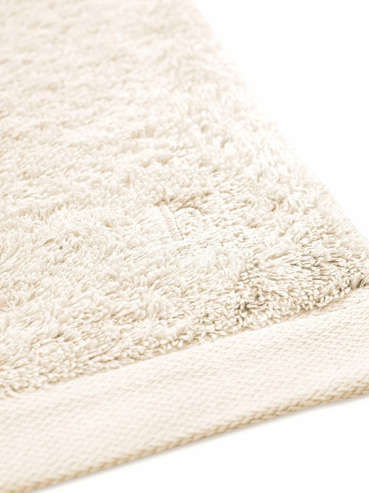 Detail von cremefarbenem Pura Frottier mit glattem Saum