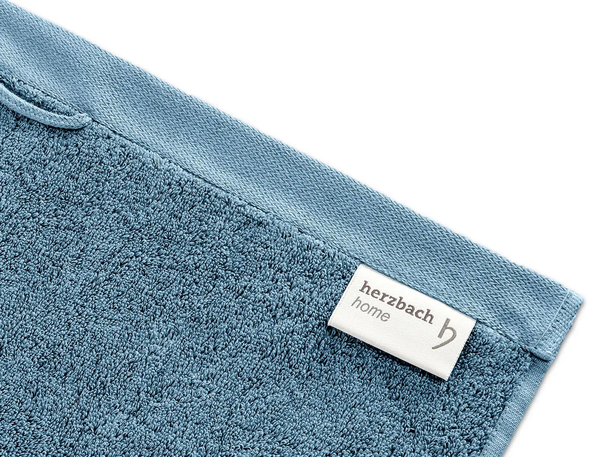 Nahaufnahme von blauem Pura Frottier mit eingenähtem Etikett