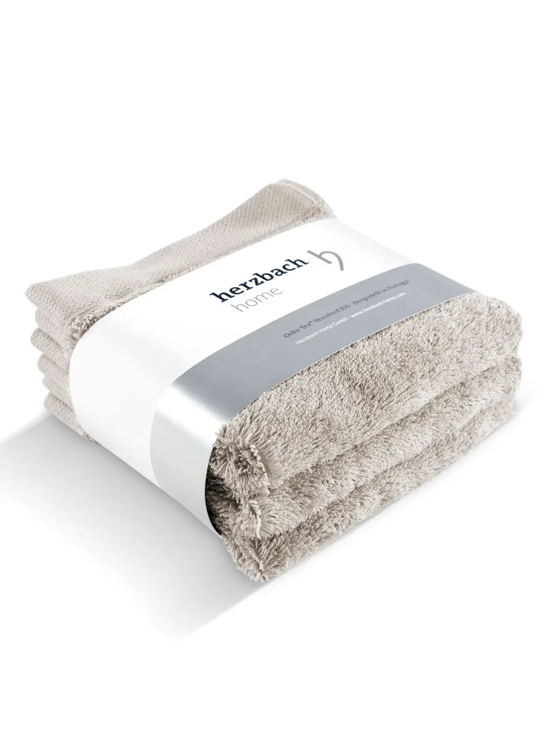 Drei gefaltete sandgraue Pura Seiftücher mit Herzbach Home Papierbanderole