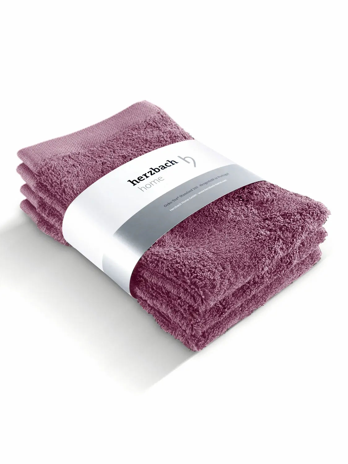 Drei gefaltete malvefarbene Pura Gästehandtücher mit Herzbach Home Papierbanderole