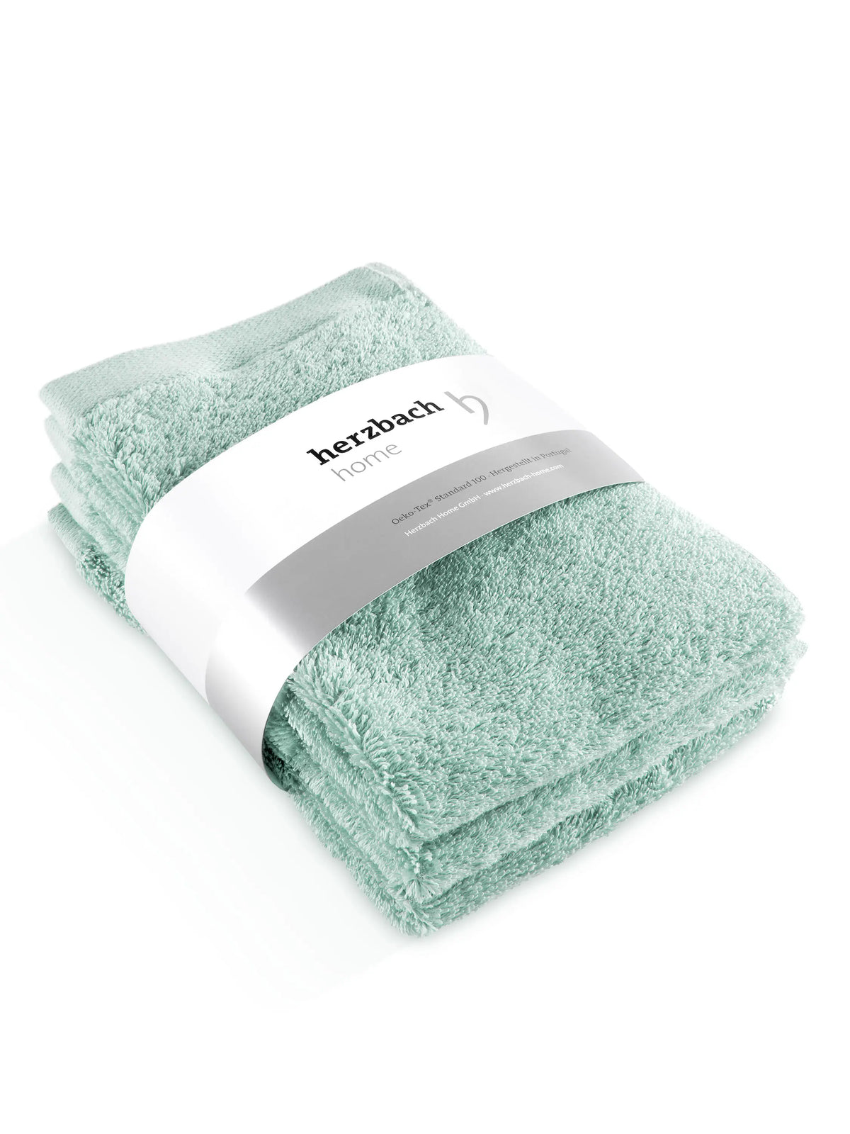 Drei gefaltete mintfarbene Pura Gästehandtücher mit Herzbach Home Papierbanderole