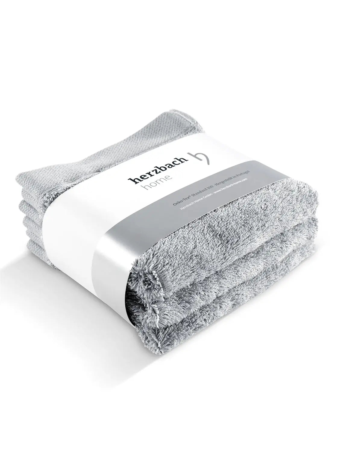Drei gefaltete silbergraue Pura Seiftücher mit Herzbach Home Papierbanderole