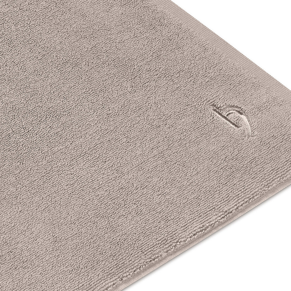 Pura Badvorleger Sandgrau – Detailaufnahme der dichten Frottier-Oberfläche und des eingestickten herzbach home Logos in der Ecke