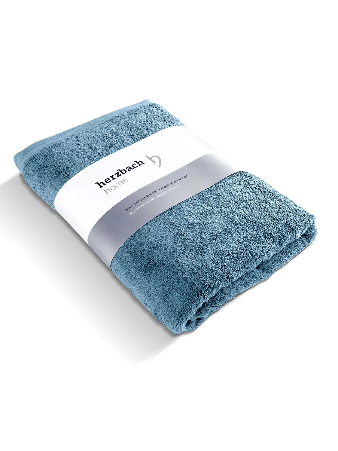 Gefaltetes blaues Pura Badetuch mit herzbach home Papierbanderole

