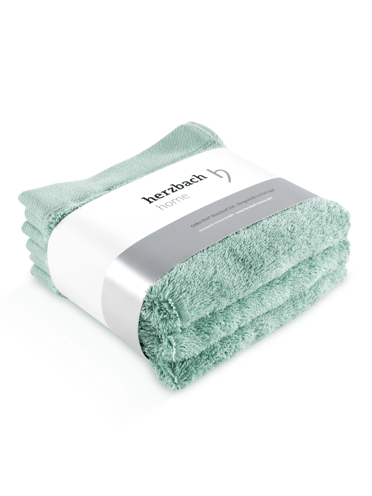 Drei gefaltete mintfarbene Pura Seiftücher mit Herzbach Home Papierbanderole
